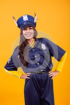 Beautiful young woman wearing Police costume over yellow background