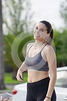 Beautiful young woman wearing a sport bra and tights smiling and looking at the camera . Healthy lifestyle and sport concept