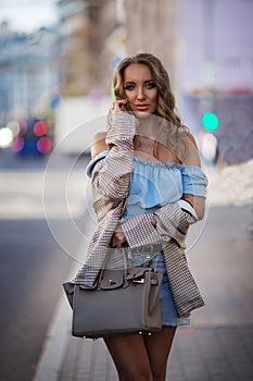 Beautiful young woman wearing stylish clothes walking on the street