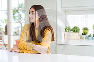 Beautiful young woman wearing yellow sweater looking to side, relax profile pose with natural face with confident smile