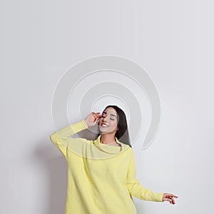 Beautiful young woman wearing yellow warm sweater on white background