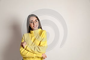 Beautiful young woman wearing yellow warm sweater on white background. Space for text