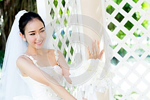 Beautiful young woman on wedding day in white dress in the garden. Female portrait in the park.