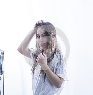 beautiful young woman with wet hair in a wet white t-shirt