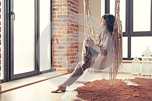 Woman wearing cashmere nightwear relaxing in cabin near fireplace photo