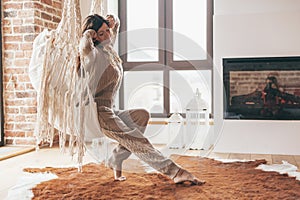 Woman wearing cashmere nightwear relaxing in cabin near fireplace photo