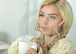 Beautiful young woman with white cup