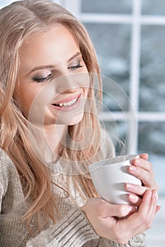 Beautiful young woman with white cup