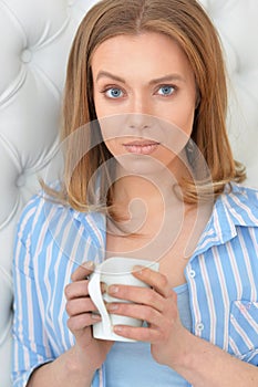 Beautiful young woman with white cup