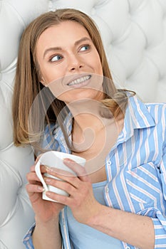 Beautiful young woman with white cup