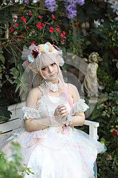 Beautiful young woman with white lolita dress with flowers garden Japanese fashion photo