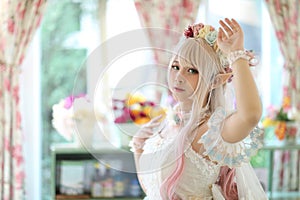 Beautiful young woman with white lolita dress with flowers garden Japanese fashion