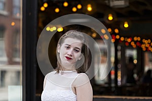 Beautiful young woman in white top and head band with head tilted