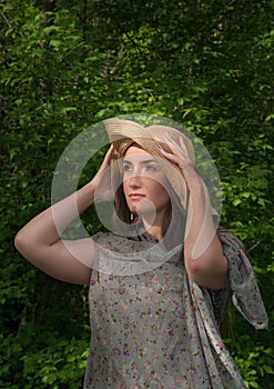 Beautiful young woman in wide hat on the sun