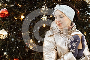 Beautiful young woman in winter clothes at christmas market drinking coffee