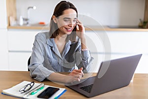 Beautiful young woman working on her laptop in her office at home