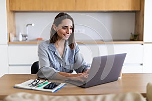 Beautiful young woman working on her laptop in her office at home