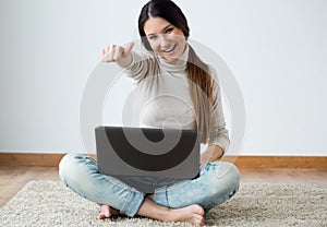 Beautiful young woman working on her laptop at home.