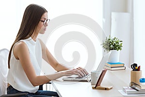 Beautiful young woman working with her laptop in the office.