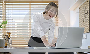 Beautiful young woman working remotely from home office, communicating by conference video call on laptop