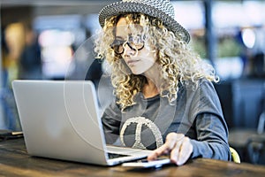 Beautiful young woman working with roaming phone device like digital travel nomad or smart work at the bar cafe - modern people