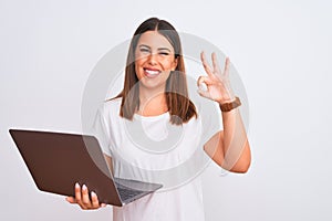 Beautiful young woman working using computer laptop over white background smiling positive doing ok sign with hand and fingers