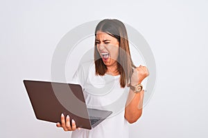 Beautiful young woman working using computer laptop over white background very happy and excited doing winner gesture with arms