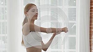 Beautiful young woman workout with warmup and stretch muscle arm and hands at home.