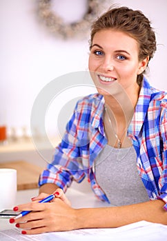 Beautiful young woman writing something in her note pad