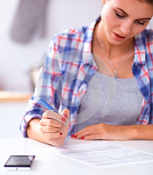 Beautiful young woman writing something in her note pad