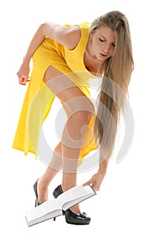 Beautiful young woman in yellow dress with book