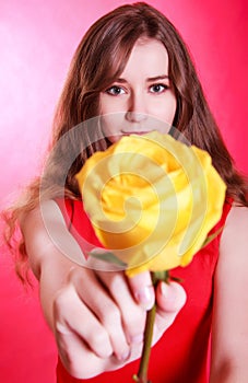 Beautiful young woman with a yellow rose