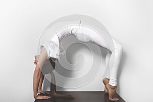 Beautiful young woman in yoga posing in asana on a studio background