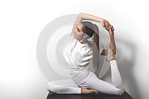 Beautiful young woman in yoga posing in asana on a studio background