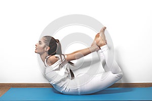 Beautiful young woman in yoga posing on a studio background