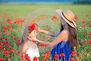 elegant young woman with child girl in poppy field, happy family having fun in nature, summer time