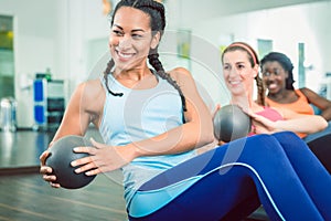 Beautiful woman exercising Russian twist with med ball for strong abs