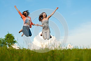 Beautiful young women happy jumping on blue sky