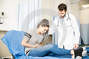 Woman with stomach ache visiting doctor photo