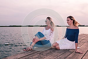 Beautiful young women sitting by the river