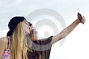 Beautiful young women using mobile phone in the street.