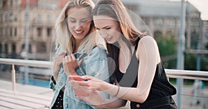 Beautiful young women watching photos on a mobile phone.