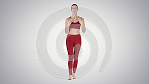 Beautiful young yoga instructor talking to camera on gradient background.