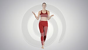 Beautiful young yoga instructor talking to camera on gradient background.