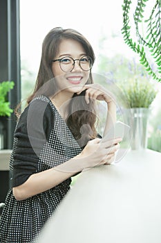 Beautiful younger asian woman with smart phone in hand toothy sm