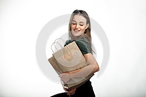 Beautiful youngwoman holding grocery shopping bag. White background. Young girl with bag under arm