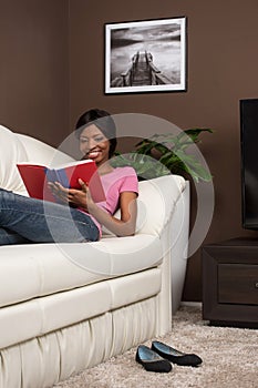 Beautiful youthful woman relaxing at home on couch.