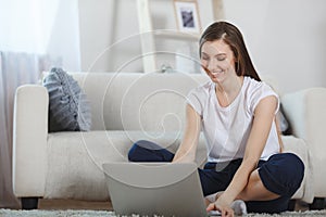 Beautiful ypung woman using laptop at home