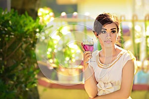Beautifull asian girl holding a glass of wine at the evening party