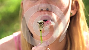 Beautifull girl blow on dandelion slow motion